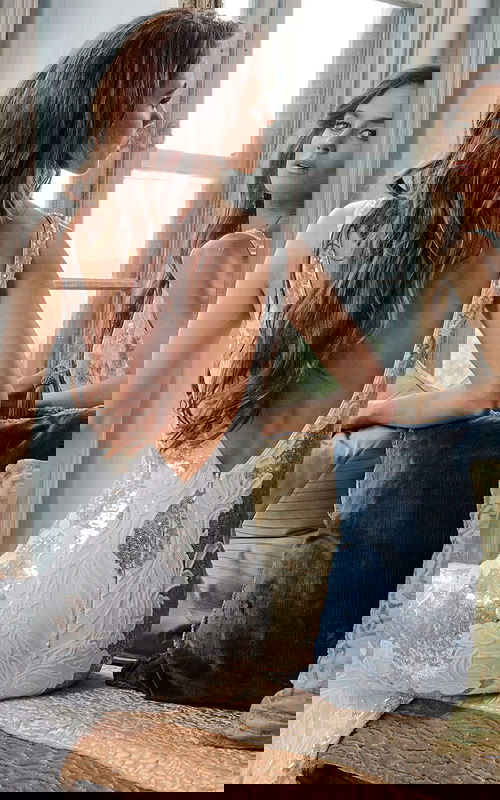 Back view of model wearing Jovani 23319 ivory gown showcasing V-shaped back