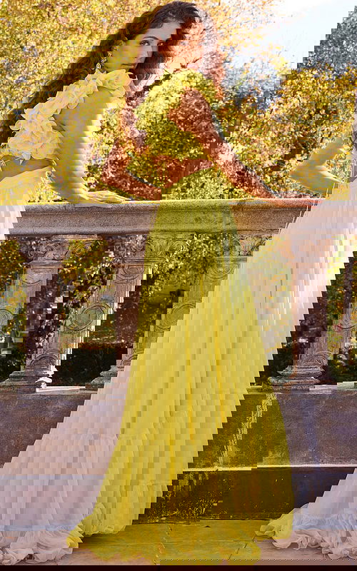 Back view of model wearing Jovani 23322 yellow dress with open back and floral appliqué