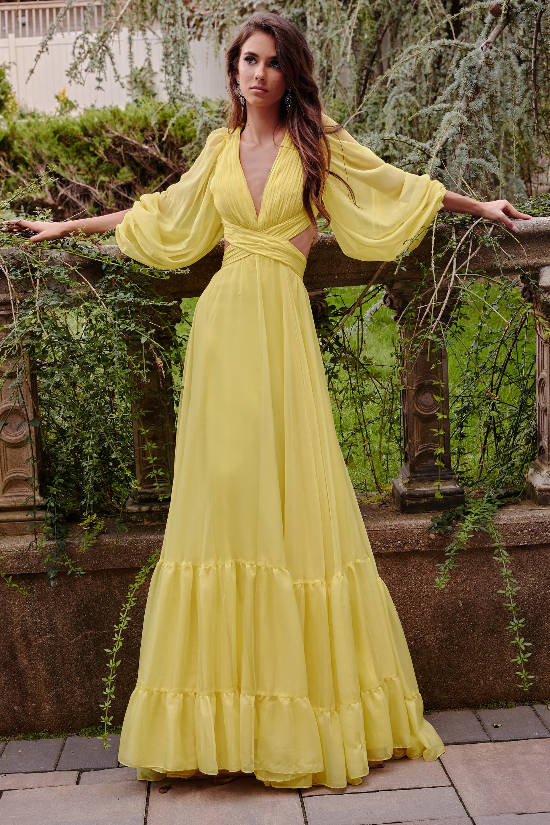 23325-6.jpg model wearing Jovani 23325 long yellow gown with V-neckline and flowing silhouette