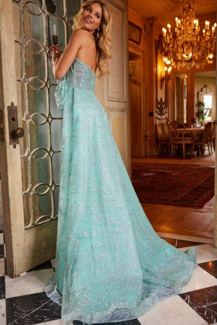 Model wearing Jovani 23361 back view showing train of green gown.