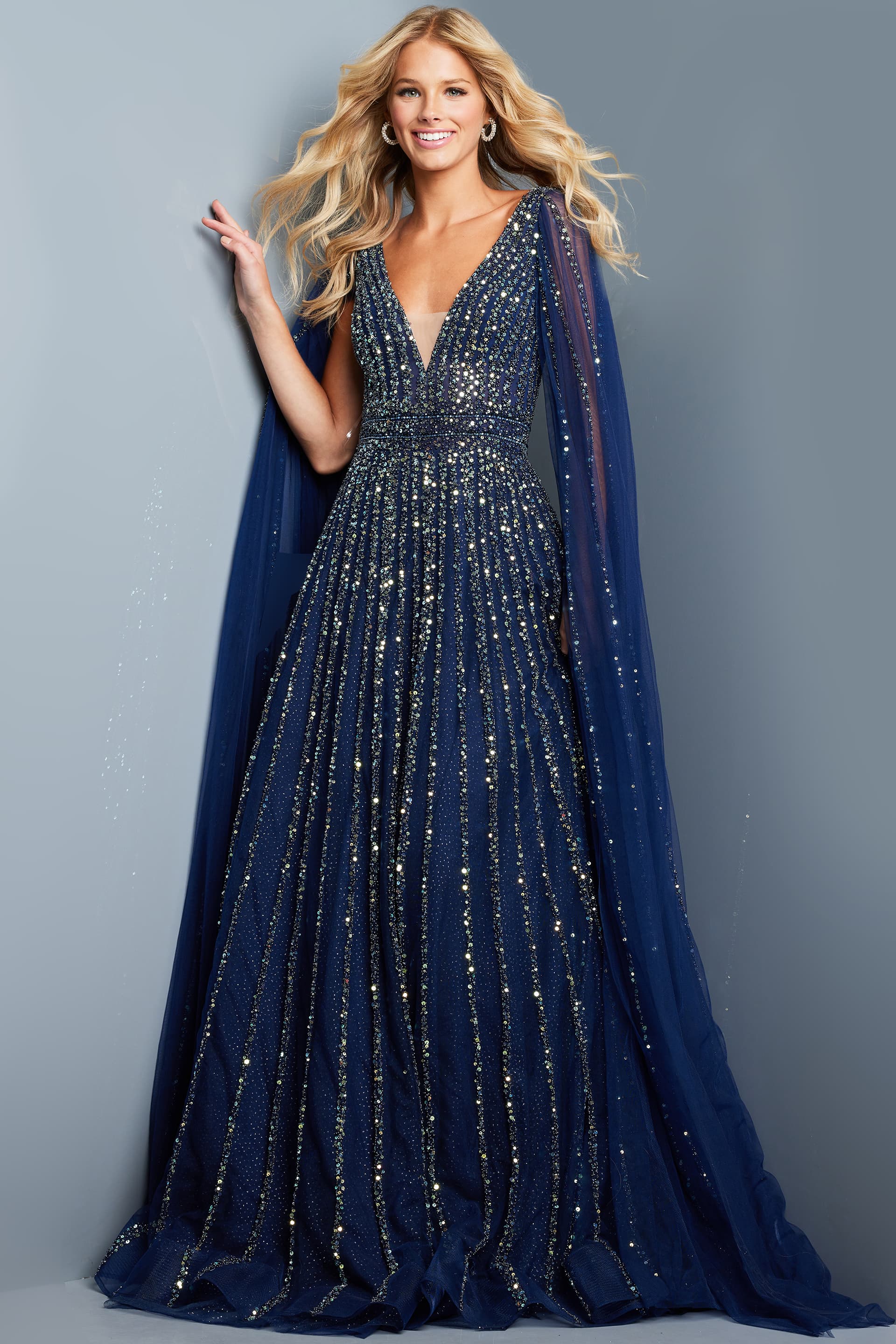 23362-204.jpg Model wearing Jovani 23362 navy dress with sequins and cape sleeve, front view.