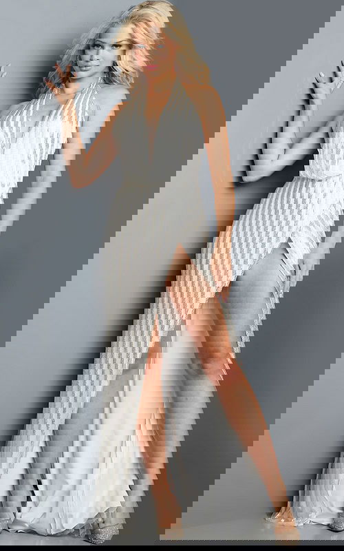 Model wearing Jovani 23372 white gown with shimmering stripes, halter neckline, and high side slit.