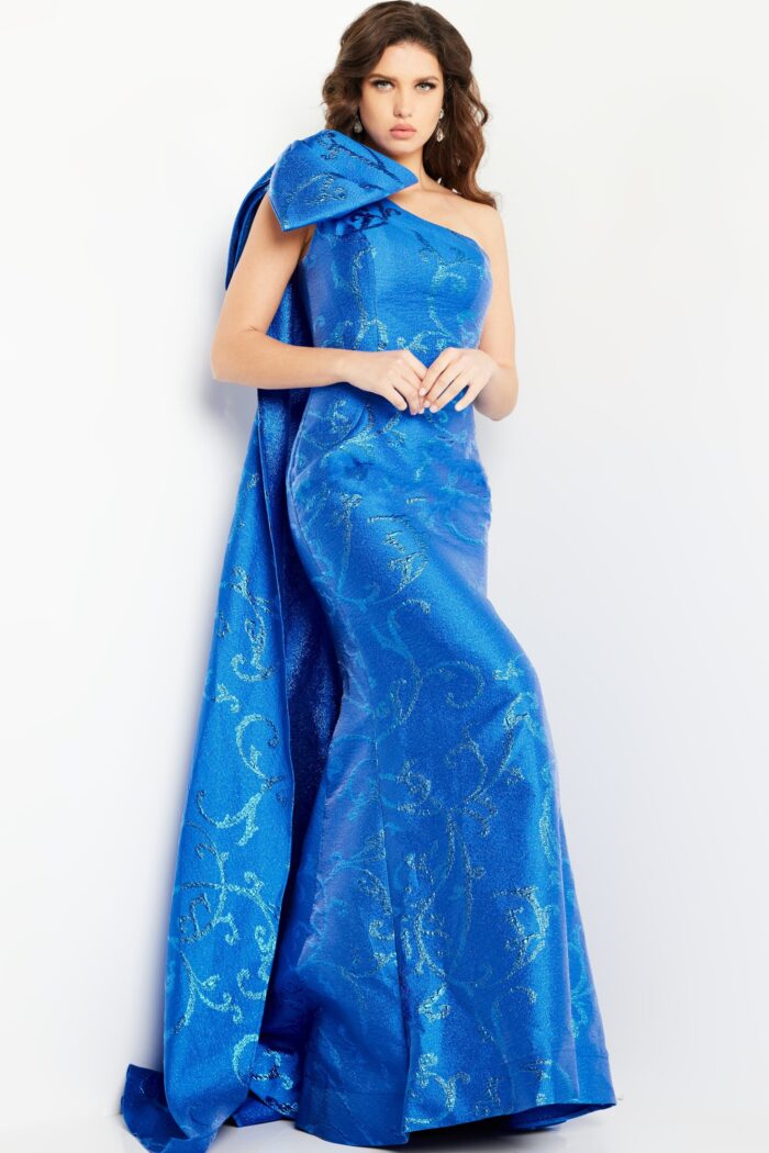 Model wearing Jovani 23742 royal blue gown featuring elegant flare and patterned fabric.