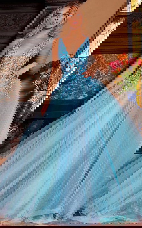 Model wearing Jovani 23577 blue gown with deep V-neckline front view.