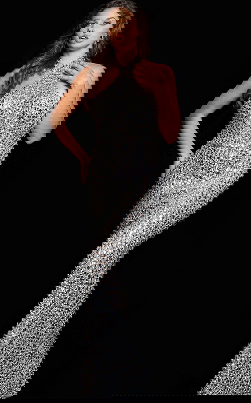 Model wearing Jovani 23652 silver long dress with halter neckline and crystal embellishments, side view.