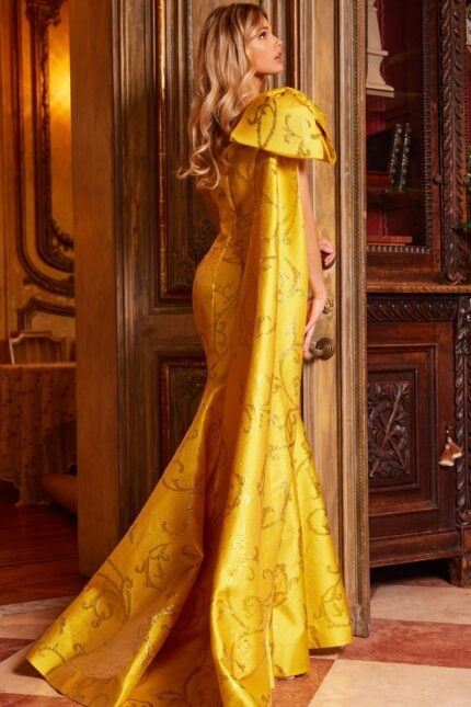 Model wearing Jovani 23742 yellow gown, back view showing flowing silhouette and train.