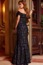 Model in Jovani 23890 black gown showcasing back details.