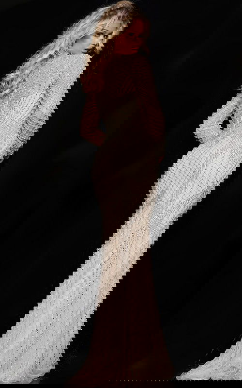 Model wearing Jovani 23950 nude dress with intricate beadwork, in back view.