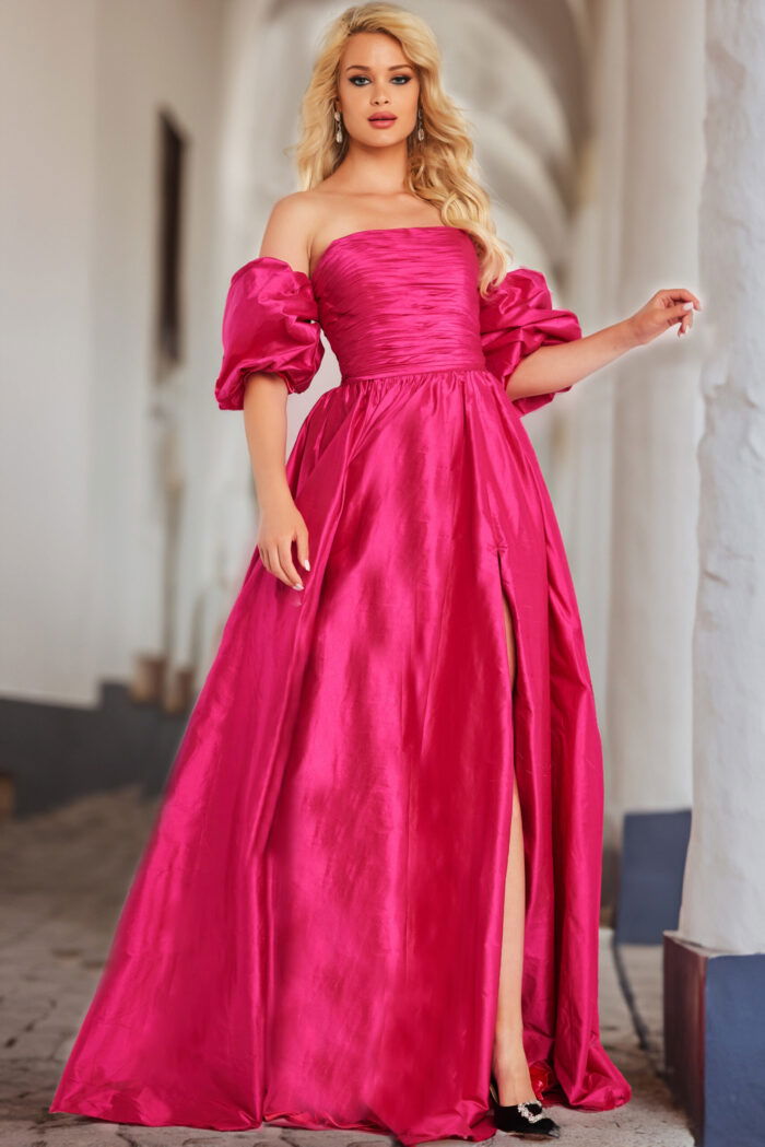 Model wearing Jovani 24099 fuchsia dress featuring off-the-shoulder neckline and puff sleeves.