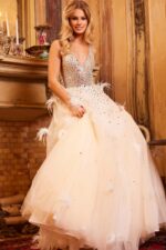 Model showcasing Jovani 24255 gown with feather accents and embellished bodice in nude.