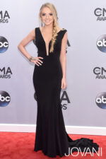 Model wearing Jovani 22884 black gown with mermaid silhouette and deep V-neckline