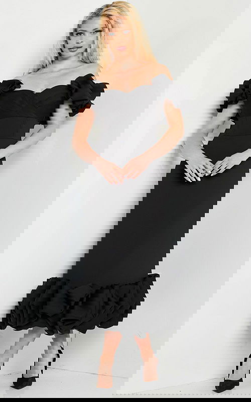 model wearing Jovani 24535 black dress with ruffled sleeves and hem, front view