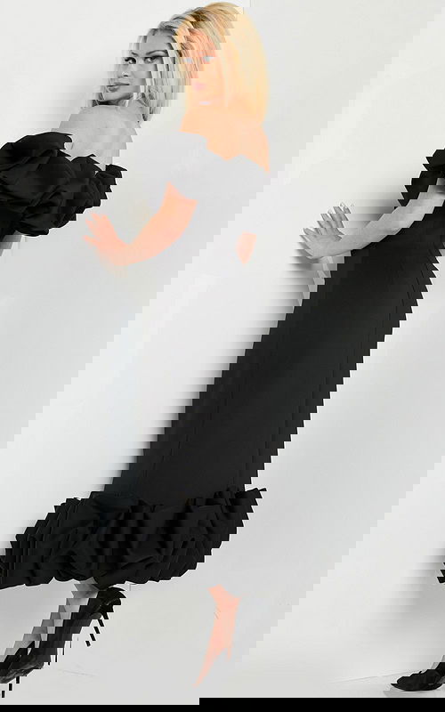 model wearing Jovani 24535 black dress, back view showcasing the silhouette and ruffles