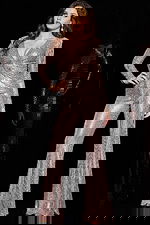 Model wearing 24566 blush jumpsuit with sequins and long sleeves, alternate front view.