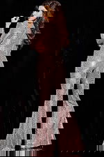 Model wearing 24566 blush jumpsuit with sequins and long sleeves, back view.