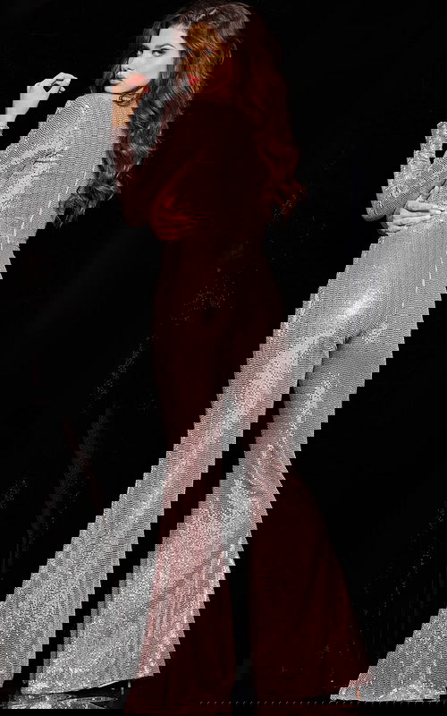 Model wearing 24566 blush jumpsuit with sequins and long sleeves, back view.