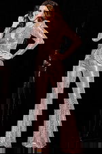 Model wearing 24566 blush jumpsuit with sequins and long sleeves, front pose.