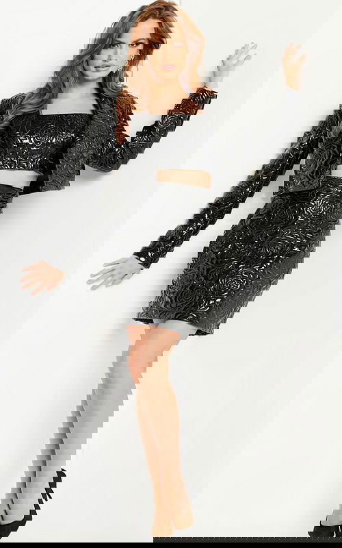 Model wearing Jovani 24568 black outfit with floral embossed design, front view.