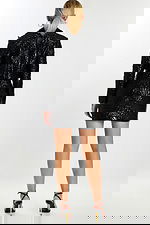 Back view of model in matching black embossed jacket and fitted skirt with floral texture.