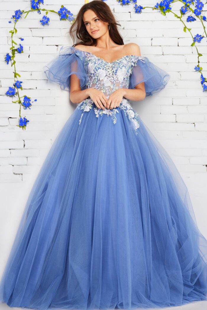 Model wearing Jovani 24575 blue ball gown with tulle skirt and floral appliqués.