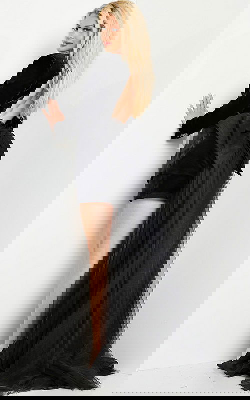 Model wearing Jovani 25741 black velvet dress with large bow accent on back view.