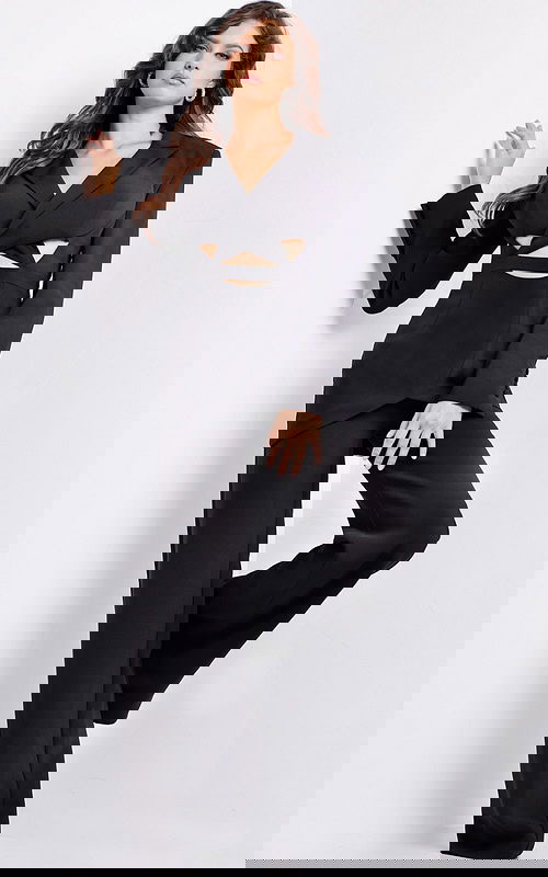 Model wearing Jovani 25743 ensemble with tailored blazer and bold cutout accents.