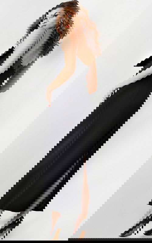 Back view of model wearing Jovani 25745 elegant black dress with a back slit.