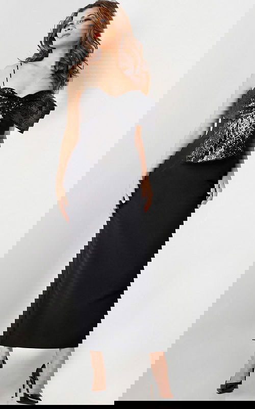 Model wearing Jovani 25745 elegant black dress with sequin bow detail and sweetheart neckline.