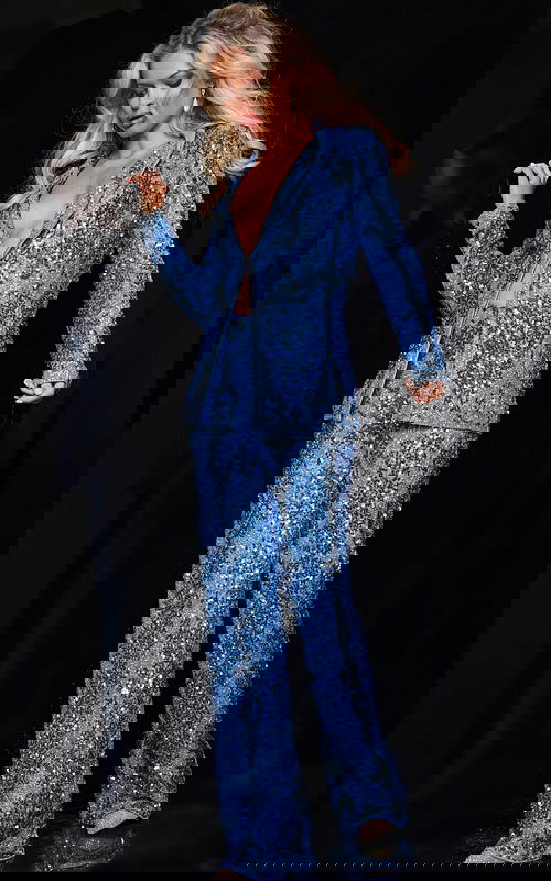 Model wearing Jovani 25886 blue sequin ensemble with deep V-neckline, front view