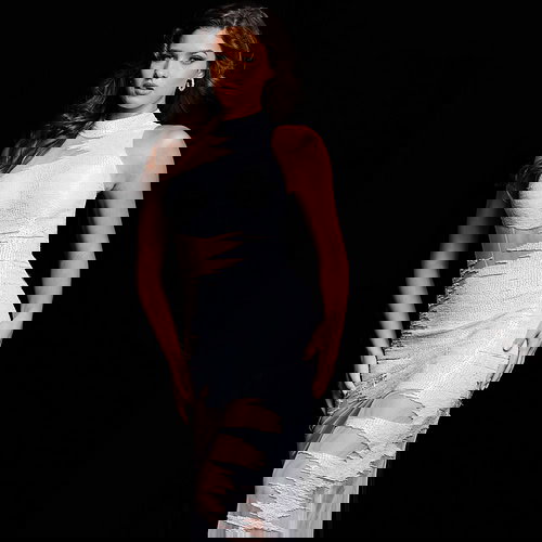 model wearing Jovani 25974 white dress with high neckline and sequined details