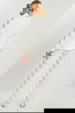 Back view of off-white fitted blazer and matching pants showing button cuff detail.