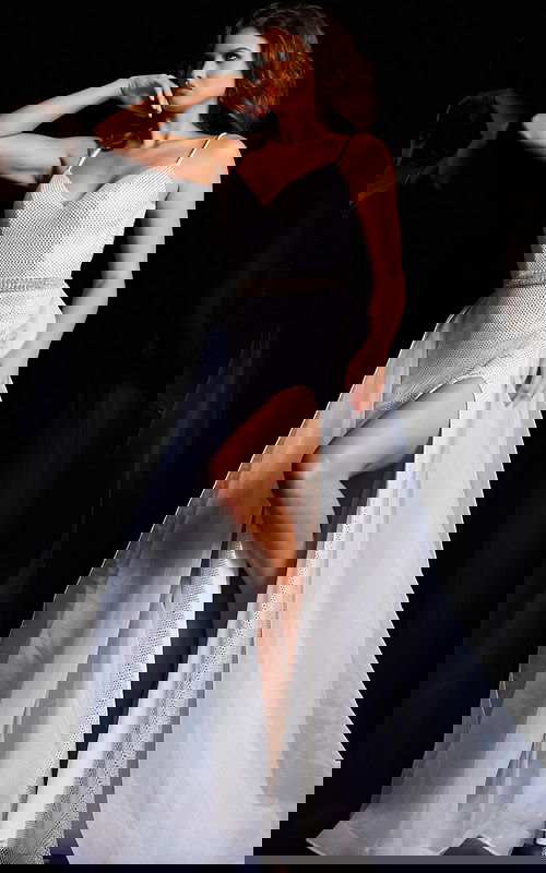 Model wearing Jovani 25990 elegant white gown with V-neckline and high slit.