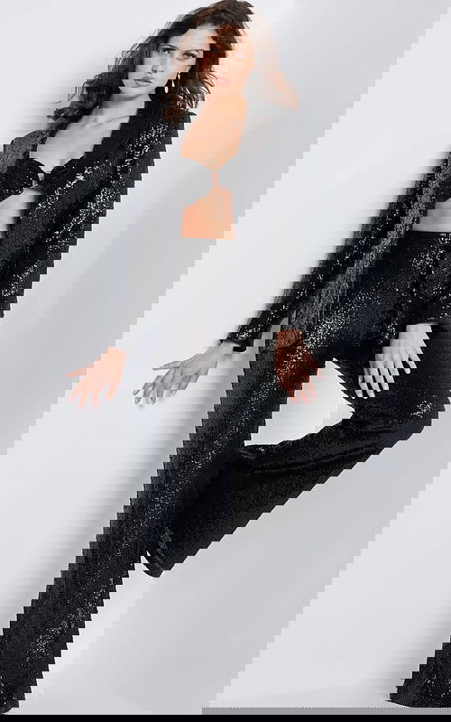 Model wearing Jovani 26042 black sequin jacket and pants set, front view.