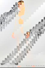 Model wearing silver sequin pantsuit with flared trousers, bralette top, and open blazer.