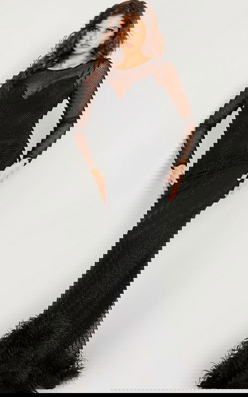 Model wearing Jovani 26047 elegant black gown with illusion neckline and fringe hem.