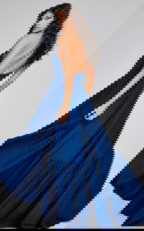 Model wearing Jovani 26152 with a navy A-line strapless gown, back view, showcasing open back.