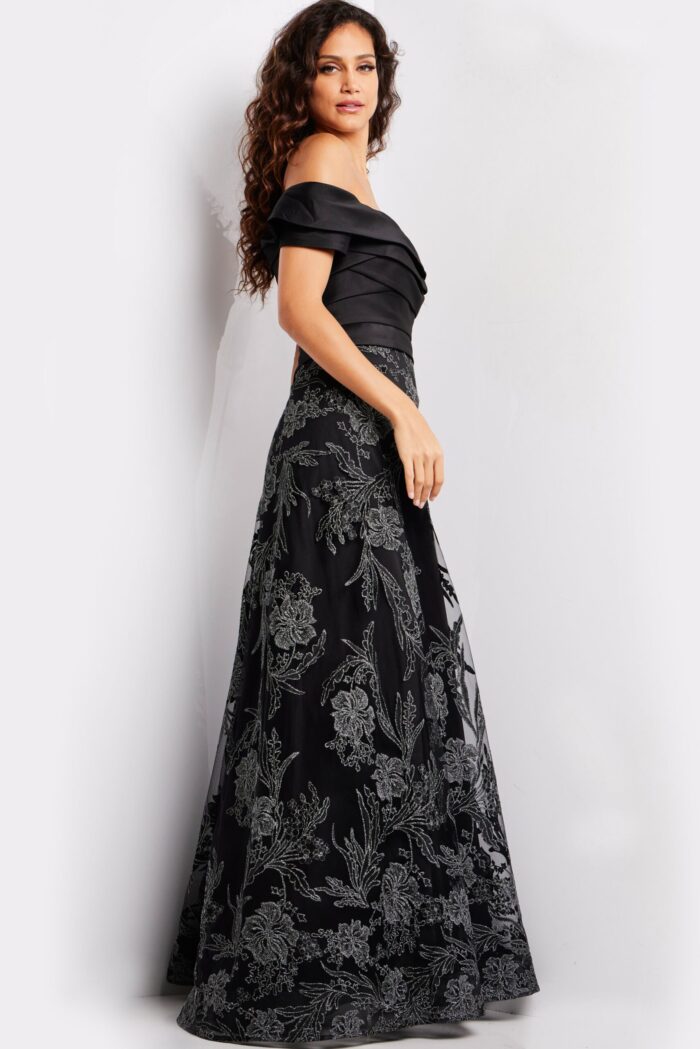 Model wearing Jovani 26186 elegant black gown, front view featuring off-the-shoulder neckline.