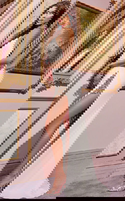 Model wearing Jovani 29495 white gown with side slit, back view.