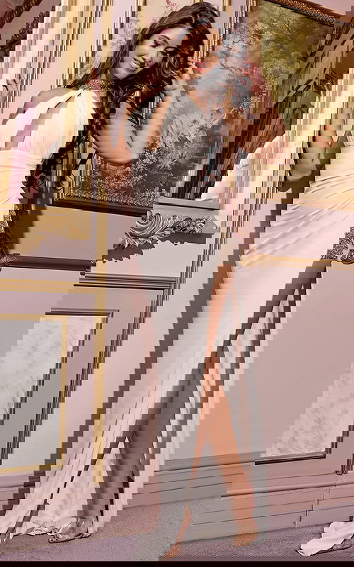 Model wearing Jovani 29495 elegant white gown with high neckline and side slit, front view.