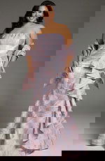 Elegant strapless gown with textured pastel fabric and cascading ruffle detail.