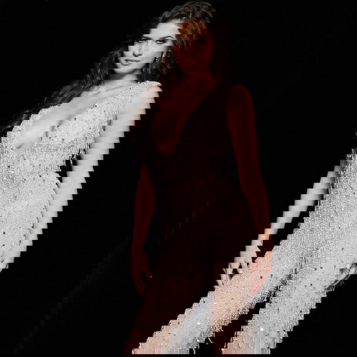 Model wearing Jovani 32592 nude gown front view with deep V-neckline and beaded embellishments.