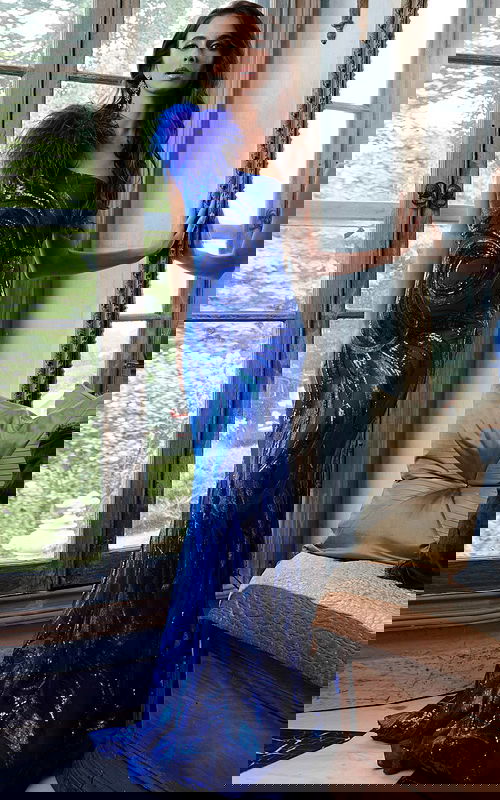 Model wearing Jovani 32596 royal blue gown with feather detail at shoulder, front view.