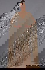 Full length view of a beaded column gown with sheer cape sleeves and defined waist