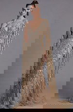 Front view of a beaded column gown with deep V neckline and draped cape sleeves