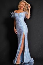 Model wearing Jovani 36419 elegant blue dress with feather embellishments and high slit, front view.