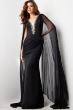 model in Jovani 36473 floor-length black gown with beadwork and cape sleeves