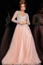 Model in 36533 blush dress with detailed long sleeves and a V-neckline.