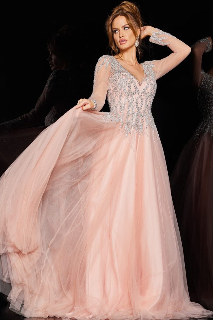 Model wearing 36533 blush dress with deep V-neckline and long embellished sleeves.