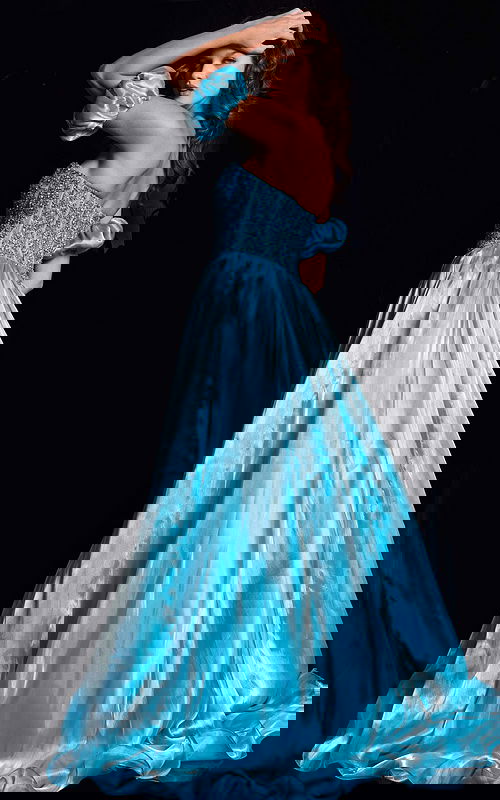 Model wearing Jovani 36591 blue ball gown showcasing the back with off-the-shoulder puff sleeves and flowing skirt.