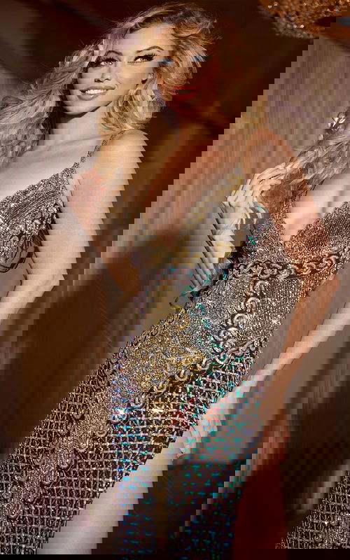 Model wearing Jovani 36643 elegant gown with deep V-neckline and embellishments in black.